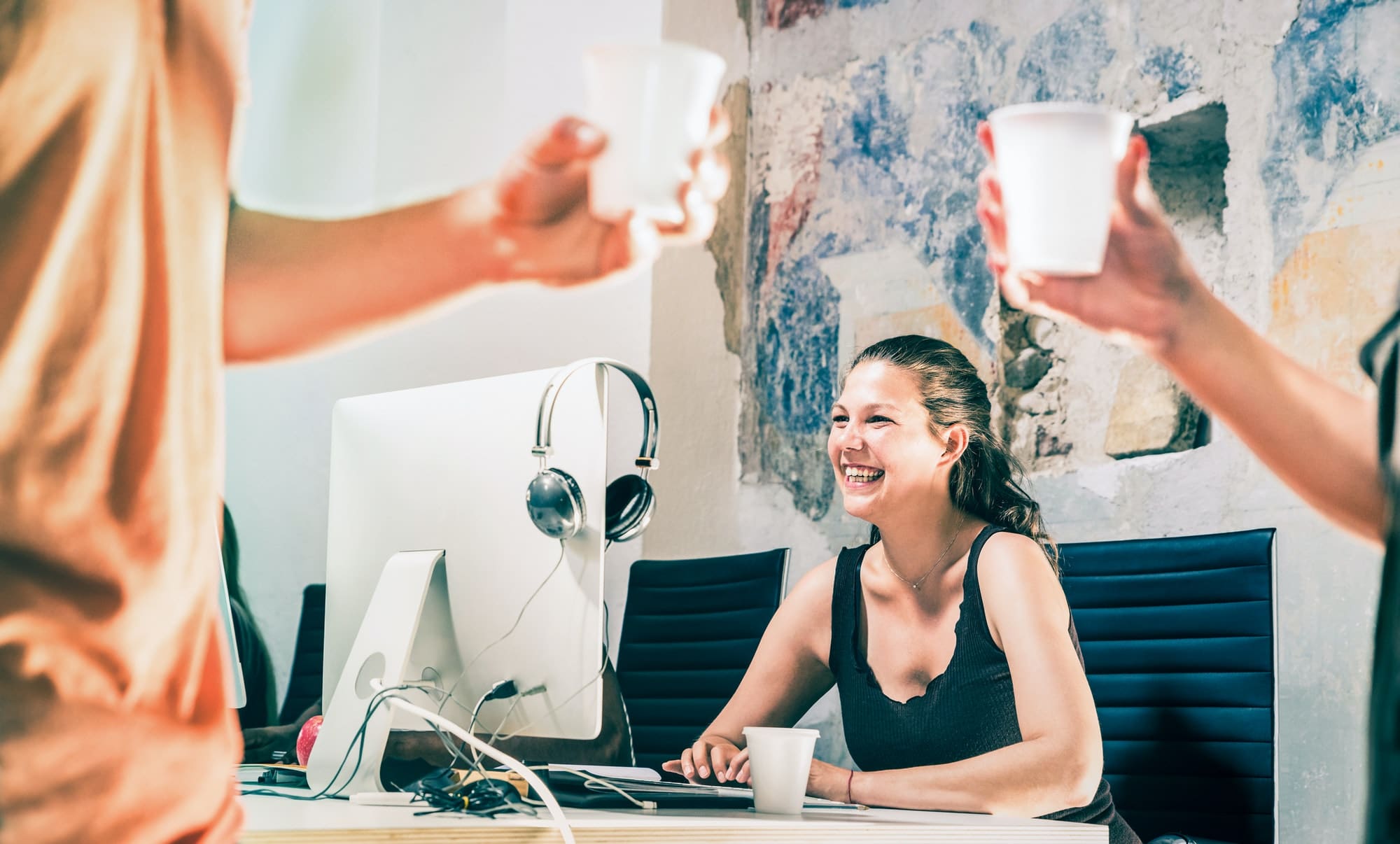 Young business woman having fun working at computer with coworkers on coffee break