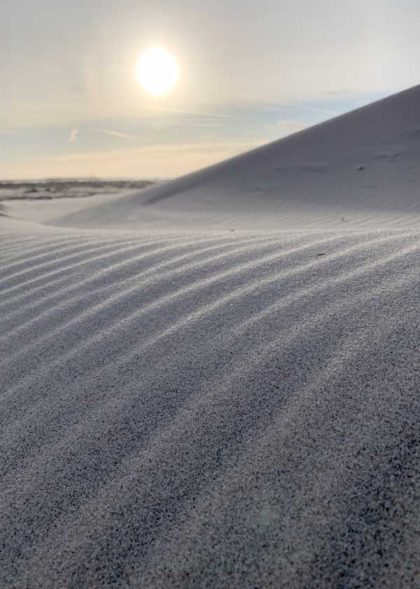 Dagens sidste lys spiller i sandet og danner fantastiske drømmeagtige mønstre