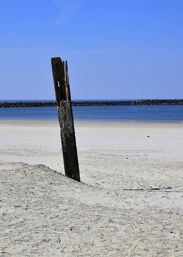Pind i sandet ved indsejling til havnen i Hvide Sande på en dejlig sommerdag
