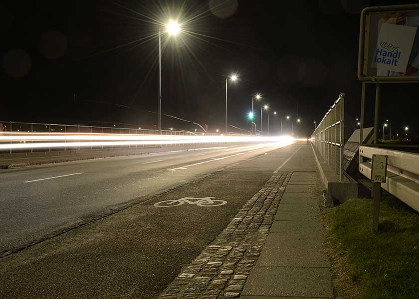 Afvandingsslusen i Hvide Sande ved nattetide, bilernes lygter trækker lange spor i natten