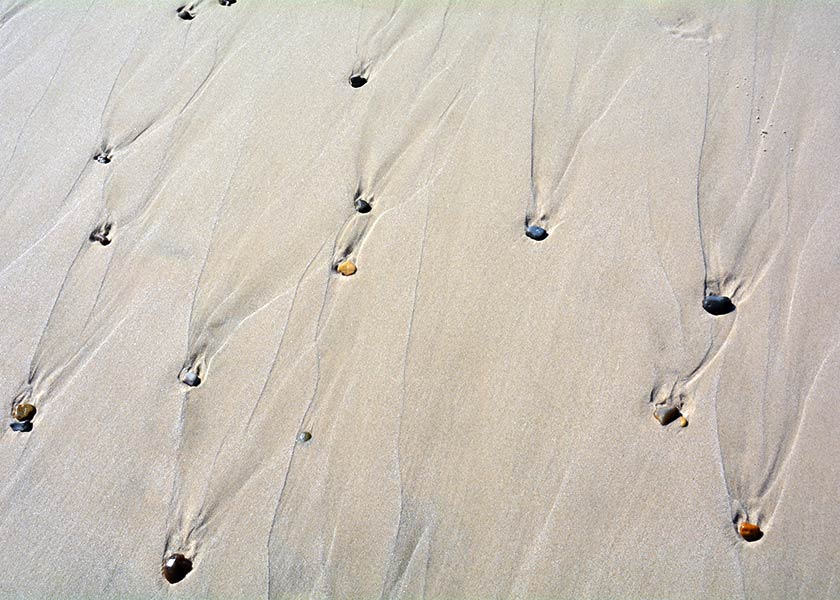 Stenene trækker forunderlige spor i sandet når vandet har trukket sig tilbage