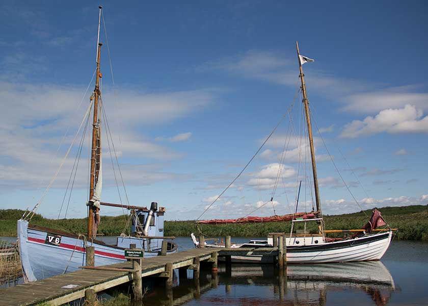 Den flot restaurerede kutter V6 og en sejlførende fjordjolle ved broen i Nymindegab