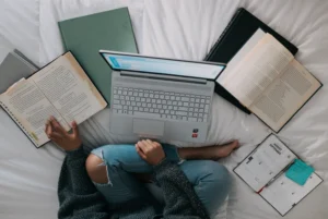 Photo of someone working on a laptop with books open