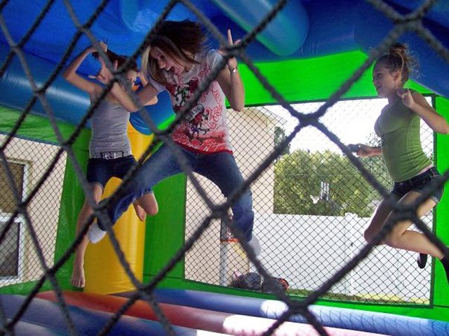 Teens and Adults Jumping inside a bounce house rental