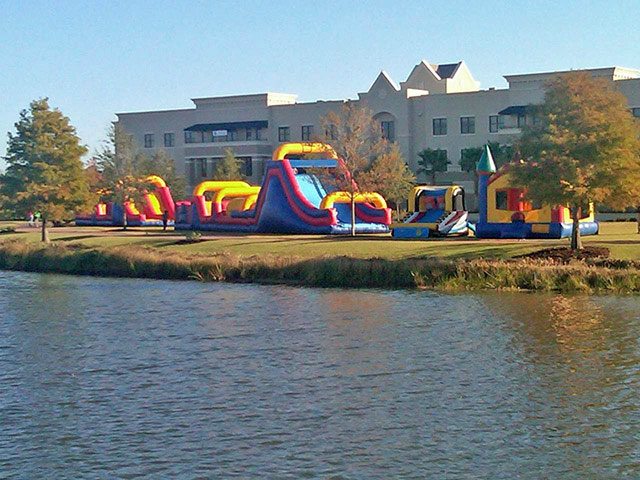 72' Obstacle Course, 52' Obstacle Course, Bounce House & Basketball Games At Large Community Event on a lake